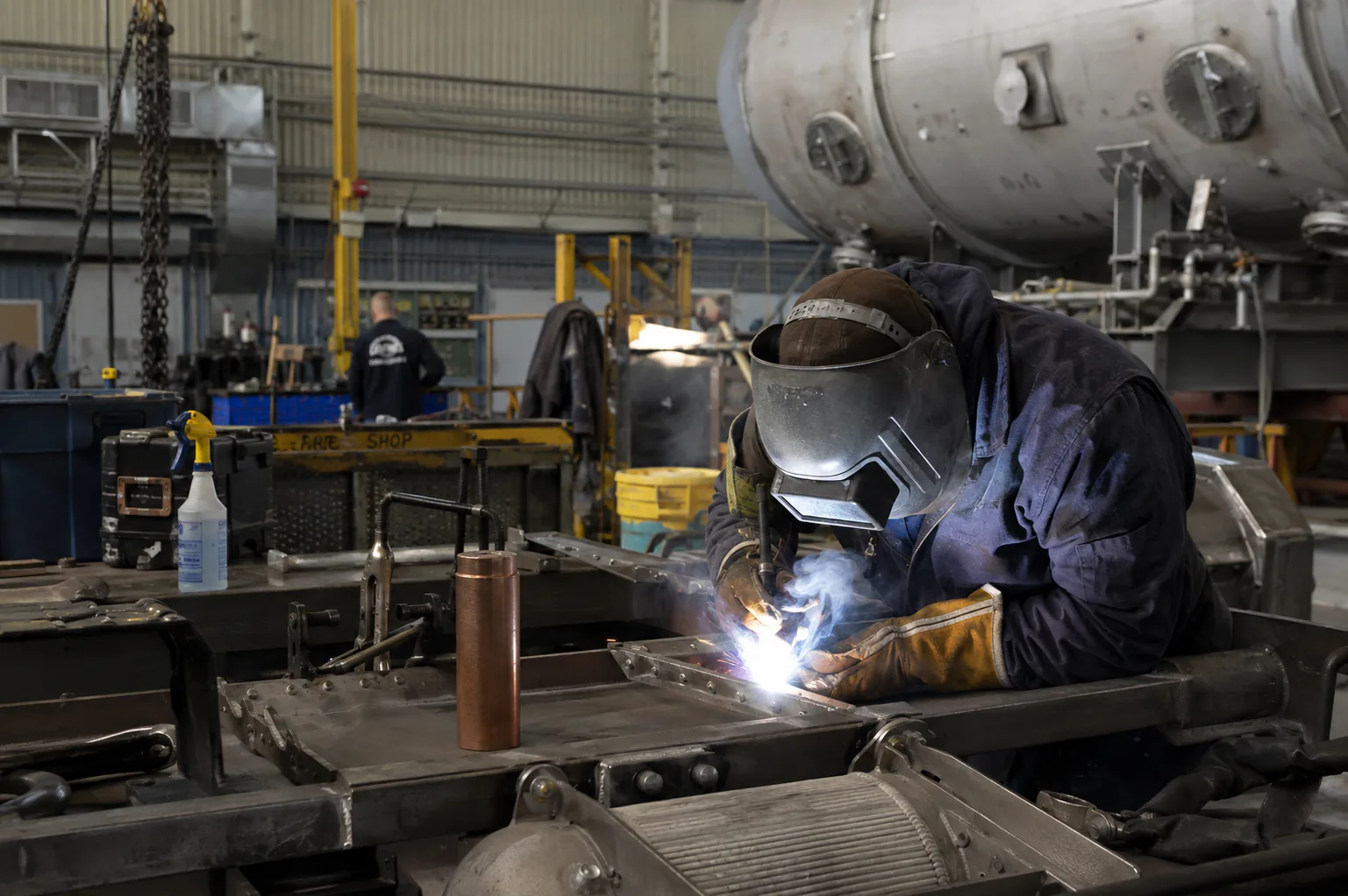 Welder working on a steel weldment in a union fabrication shop